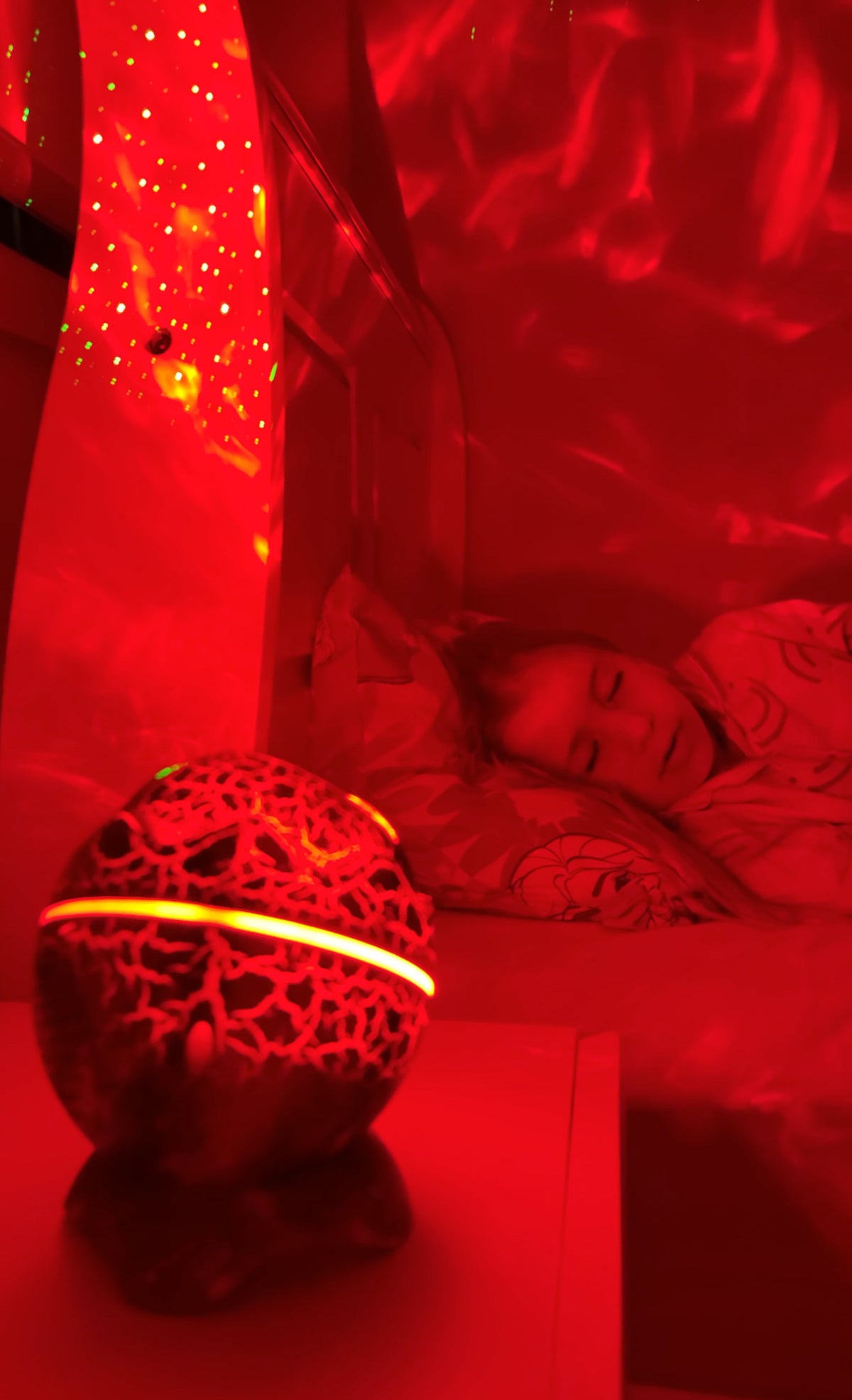 Child asleep with red nightlight on