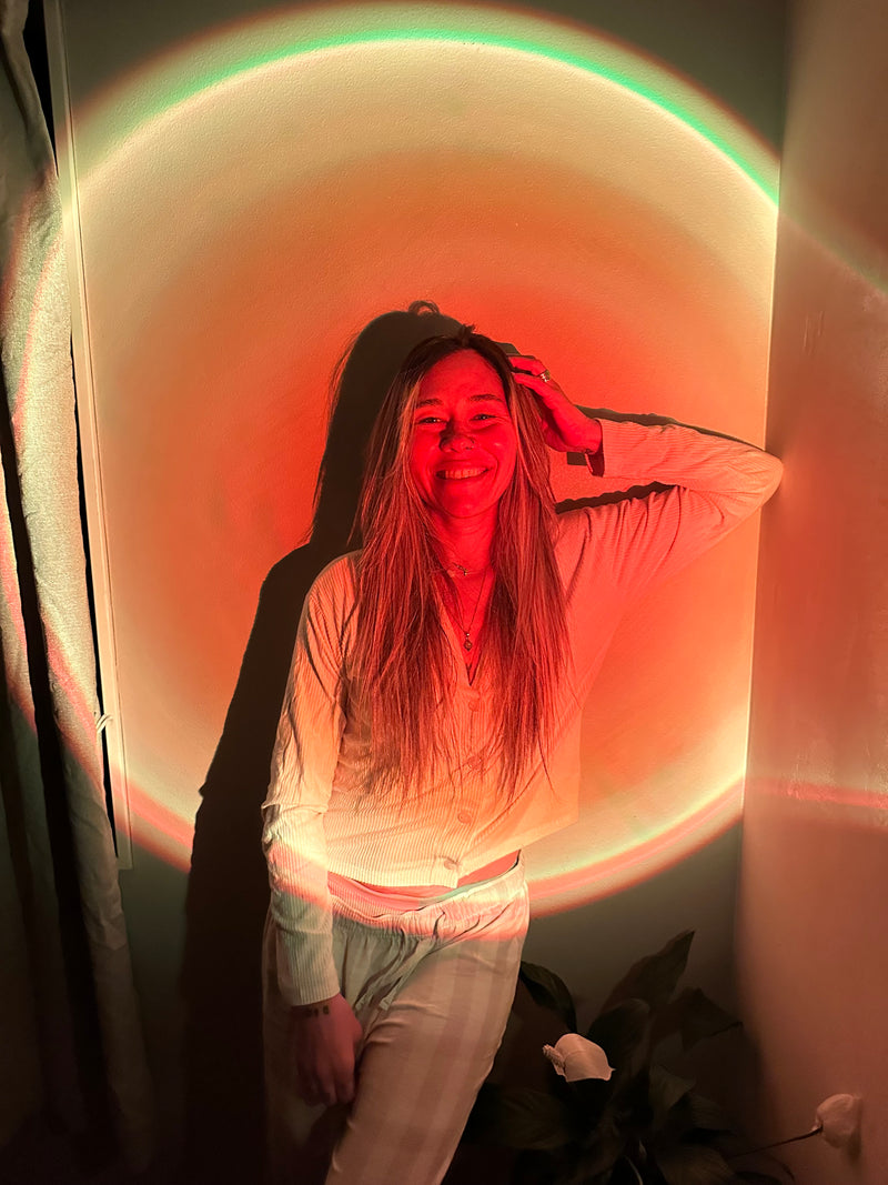 Nat standing in a warm glowing orange sunset lamp